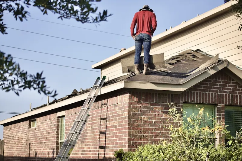 Professional roofer working on a residential roof in Hamlet